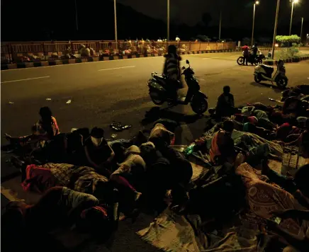  ??  ?? People sleep on a pavement after being evacuated from their homes following the gas leak at the LG Polymers plant