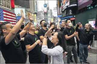  ?? SASHA MASLOV — THE NEW YORK TIMES ?? A crowd gathers for Robinhoo’s initial public offering in Times Square in New York on Thursday. Robinhood’s stock opened at $38, the same as its IPO price, and then declined, a sign of investor hesitancy.