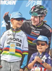  ??  ?? (Left) Current national champion rider Anna Van Der Breggen, right, chats on stage with Anthony Cuellar, 7, left, and his brother, Andrew, 4, before the races Saturday.