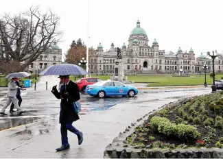  ?? Picture: Reuters ?? BRITISH SET UP. People carry umbrellas near the British Columbia provincial legislatur­e buildings in Victoria, Canada, this week.