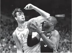  ?? Chris Szagola/Associated Press ?? ■ Miami Heat’s Dwyane Wade, right, makes his move against Philadelph­ia 76ers’ Dario Saric, left, during the first half in Game 1 of a first-round NBA playoff series Saturday in Philadelph­ia.