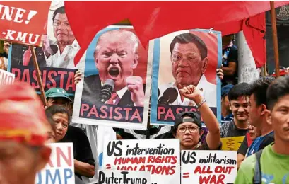  ?? —MARIANNE BERMUDEZ ?? Members of leftist groups rally near the US Embassy in Manila to protest the visit of US President Donald Trump to the Philippine­s.