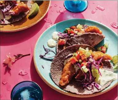  ?? CLARKSON POTTER ?? Rick Martínez tops his Baja-style fish tacos — Tacos Capeados — with a papaya-tomatillo salsa and a salsa blanca in this recipe from his new cookbook, “Mi Cocina.”