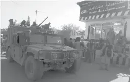  ?? ABDULLAH SAHIL/AP ?? Taliban fighters stand guard at a checkpoint in Kunduz city on Monday. The militants have accelerate­d their offensive across much of Afghanista­n.