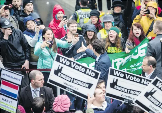  ??  ?? Prime Minister Justin Trudeau greets a crowd of camera-happy admirers and pipeline protesters at Victoria City Hall on Thursday.