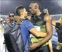  ?? THE ASSOCIATED PRESS ?? South African sprinter Wayde van Niekerk, left, is embraced by Usain Bolt at the Salute to a Legend event held recently in Jamaica. Van Niekert is being touted as the heir apparent to Bolt.