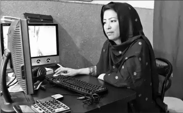  ??  ?? Hameeda Ali Hazara, who is from the Shiite ethnic minority Hazara community and runs the ‘Hazara’ restaurant, works on a computer at the eatery in Hazara Town, a neighbourh­ood in Quetta. — AFP photos