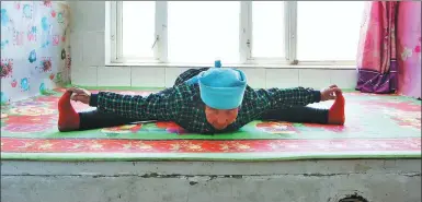  ??  ?? A senior resident practices yoga at home on a kang, a heatable brick bed.