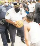  ??  ?? Police and community members gathered on court at Jackson Houses in the Bronx on Tuesday to pay tribute to Brandon Hendricks (inset).