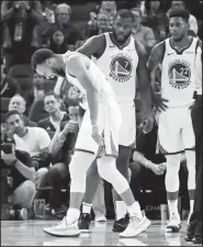  ?? AP/BEN MARGOT ?? Golden State Warriors’ Stephen Curry (left) grimaces as Eric Paschall (7) and Glenn Robinson III (22) watch, after Phoenix Suns’ Aron Baynes fell onto Curry during the second Wednesday in San Francisco.