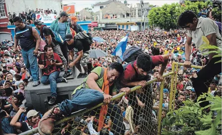  ?? OLIVER DE ROS THE ASSOCIATED PRESS ?? Thousands of Honduran migrants rush across the border with Mexico in Tecun Uman, Guatemala, on Friday.