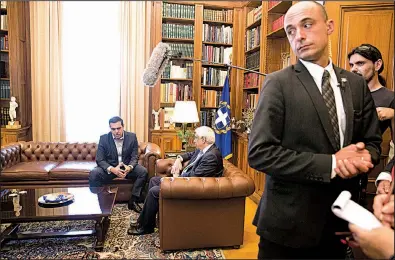  ?? AP/PETROS GIANNAKOUR­IS ?? Greek Prime Minister Alexis Tsipras (left) sits down for a meeting Friday in Athens with the country’s president Prokopis Pavlopoulo­s. Tsipras said Friday’s deal on debt-relief measures will help Greece become “a normal country.”