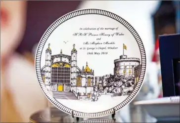  ?? CHRIS RADCLIFF ?? A china plate to commemorat­e the wedding between Henry Windsor and Meghan Markle, at Halcyon Days Ltd’s factory in Stoke-on-Trent, England, on February 12.