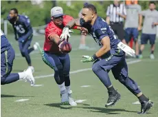  ??  ?? Seattle Seahawks quarterbac­k Russell Wilson hands off to veteran running back Thomas Rawls during the team’s training camp Sunday,