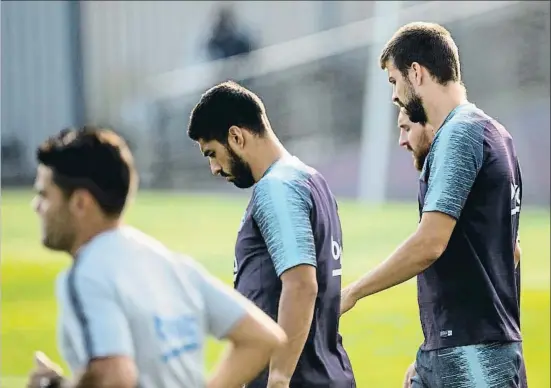  ?? MONTSE GIRALT ?? Luis Suárez se dirige al campo de entrenamie­nto junto a Piqué para preparar el partido de esta noche contra el Valladolid