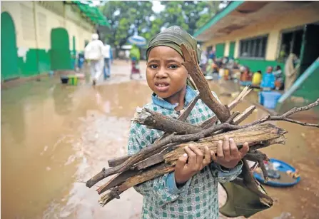  ??  ?? HARD TIMES: A child collects fire wood at the Grand Mosque in PK5, a nearby Muslim quarter in Bangui, which is also under siege. Many are sheltering in the mosque