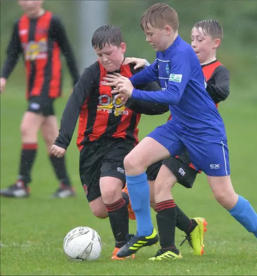  ?? Photos: Ken Finegan ?? Larry Brennan of Bellurgan and Leon Yore of Glenmuir compete for possession during their under-13 match.