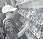  ?? 2018 PHOTO BY TY LOHR/ THE EVENING SUN ?? Josiah Borwer, 12, looks through comic books at Kirby Comics.