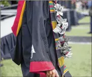  ??  ?? A graduate sports a money wreath along with graduation regalia during Clark Atlanta University’s ceremony at Panther Stadium on Monday.