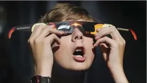  ??  ?? A boy tries out glasses in Salt Lake City in preparatio­n for the solar eclipse.