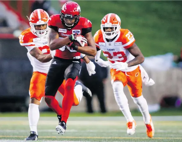  ?? THE CANADIAN PRESS ?? B.C. Lions’ Otha Foster III, left, and Anthony Thompson chase Calgary Stampeders receiver Kamar Jorden, who made a highlight-reel catch that led to a touchdown.