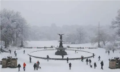  ?? Photograph: Andrew Kelly/Reuters ?? People gather near the Bethesda Fountain as snow falls in Central Park in New York City on Sunday.