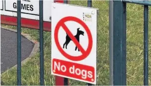  ??  ?? A sign banning dogs from a play park