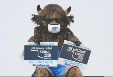  ?? The Associated Press ?? MASCOT: Rumble, the mascot of the Oklahoma City Thunder NBA basketball team, holds signs encouragin­g participat­ion in the U.S. Census, at a drive-thru Census Mobile Questionna­ire Assistance (MQA) event outside the state Capitol in Oklahoma City, Friday.