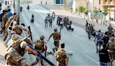  ??  ?? L’esercito libanese a sinistra e le forze di sicurezza a destra intervengo­no tra i manifestan­ti nel centro della capitale Beirut