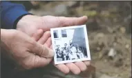  ??  ?? Duncan Atkinson holds up an image of his family, from left: him with cat Hathaway, brother David, sister Christie and brother Doug, holding Calico