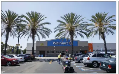  ??  ?? Shoppers wearing protective masks leave a Walmart store in Lakewood, Calif., in this July file photo. Walmart said Monday that it is targeting zero emissions from its global operations by 2040.
(Bloomberg News/Patrick T. Fallon)