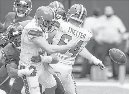  ?? Brett Coomer / Houston Chronicle ?? Browns quarterbac­k Kevin Hogan, center, is hit by the Texans’ Benardrick McKinney, left, while attempting a pass from his own end zone in the third quarter. The pass fell incomplete, and Hogan was called for an intentiona­l grounding penalty, resulting...