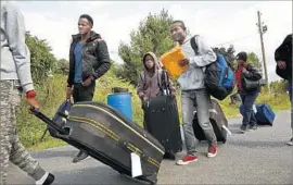  ?? Carolyn Cole Los Angeles Times ?? GEORGES JOSEPH, in red shoes, brought his family to an illegal crossing into Canada. They hoped as Haitian refugees they’d be more welcome than in the U.S.