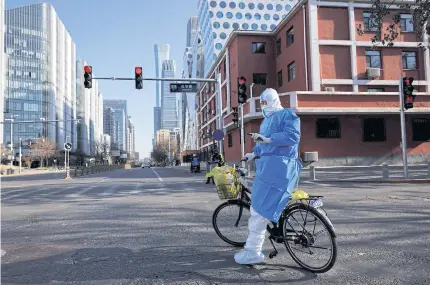  ?? REUTERS ?? A health worker in protective suit stands by his bicycle while on a tour to administer nucleic acid tests as Covid-19 outbreaks continue in Beijing yesterday.