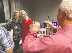  ?? MIKE STEWART/THE ASSOCIATED PRESS ?? Supporters take photos with Marjorie Taylor Greene, right, after she won the Republican nomination for her congressio­nal district.