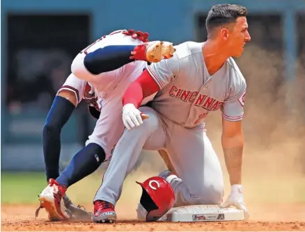  ?? THE ASSOCIATED PRESS ?? Atlanta Braves second baseman Johan Camargo, left, gets tangled up with the Cincinnati Reds’ Michael Lorenzen as he turns a double play on a Eugenio Suarez ground ball during the ninth inning Wednesday afternoon in Atlanta. Cincinnati won 6-5.