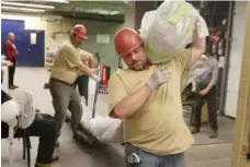  ??  ?? A worker carries half the blue whale’s jaw upon its arrival at the Royal Ontario Museum. The Trout River whale weighed 90 tons.