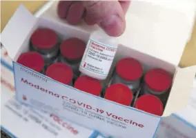  ?? (Photos: AP) ?? A man shows a vial of a Covid-19 vaccine from Moderna intended for the vaccinatio­n centre of the Klinikum in Stuttgart, Germany, yesterday.