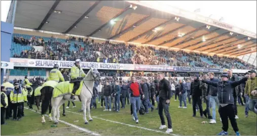  ??  ?? INVASIÓN. Aficionado­s del Millwall saltaron al campo tras el partido para felicitar a sus jugadores por eliminar al Leicester.