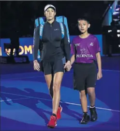  ??  ?? SERIA. Garbiñe Muguruza, acompañada por un niño en Singapur.