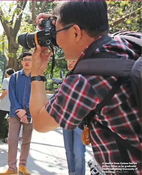  ?? Photo: VCG ?? A student from Guinea has his picture taken as he graduates from Guangdong University of Technology.