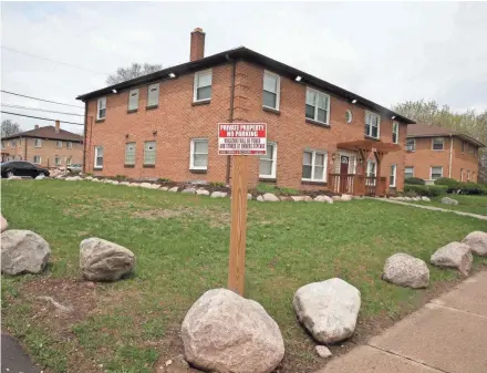  ?? RICK WOOD / MILWAUKEE JOURNAL SENTINEL ?? An apartment building on North 29th Street in Milwaukee owned by Youssef "Joe" Berrada's company features his signature boulders on the lawn. Berrada says the boulders prevent people from driving onto the properties.