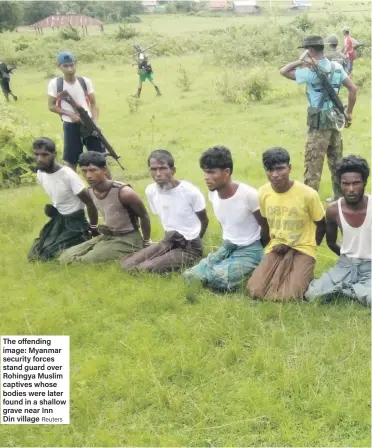  ?? Reuters ?? The offending image: Myanmar security forces stand guard over Rohingya Muslim captives whose bodies were later found in a shallow grave near Inn Din village