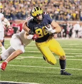  ?? Gregory Shamus/Getty Images ?? Michigan’s Luke Schoonmake­r breaks a tackle against Indians on Nov. 6, 2021 in Ann Arbor, Mich.