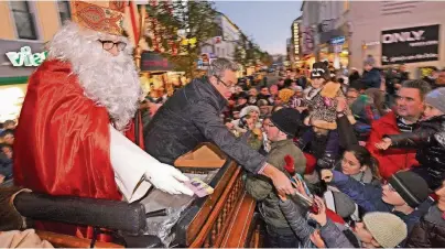  ??  ?? Auf seiner Fahrt entlang der Kölner Straße macht der Nikolaus immer wieder Station, um kleine Geschenke an die Kinder zu verteilen.