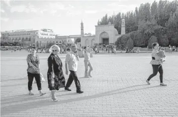  ?? GILES SABRIE/ THE NEW YORK TIMES 2019 ?? People gather outside the Id Kah Mosque in the Xianjing province city of Kashgar. A movie is part of Beijing’s propaganda campaign to push back on sanctions and criticism that Muslim Uyghurs are oppressed.