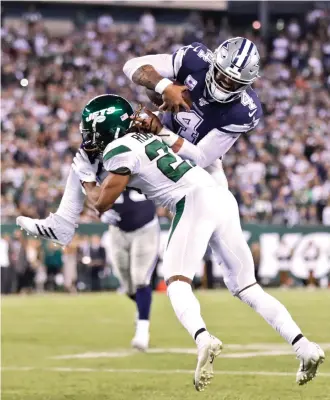  ?? Adam Hunger/Associated Press ?? ■ Dallas Cowboys quarterbac­k Dak Prescott, top, tries to leap New York Jets' Darryl Roberts on Sunday in East Rutherford, N.J.