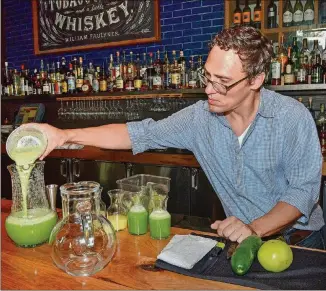  ?? CONTRIBUTE­D BY CHRIS HUNT ?? Clarke Anderson, a beverage director for Atlanta restaurate­ur Ford Fry, made his Green Ghost cocktail for the Attack of the Killer Tomato Festival in July. Made with fresh green tomato, celery, cucumber, lemon and lime juices, plus a touch of salt, the...