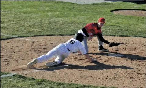  ?? Photo by Mike Frank ?? Brant Metz of Botkins dives for home plate in the third inning of Friday’s game against New Knoxville. Metz scored on the play after a wild pitch gave him the opportunit­y.