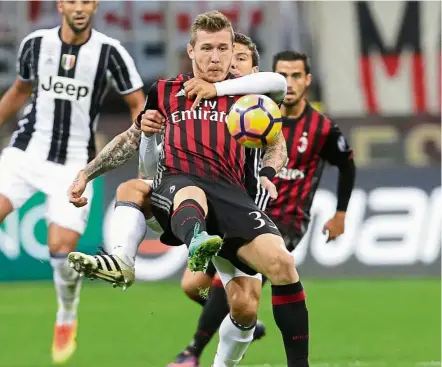  ?? — AP ?? Hands-on approach: Juventus’ Hernanes holds on to AC Milan’s Juraj Kucka during the Serie A match at the San Siro Stadium on Saturday. Milan won 1-0.